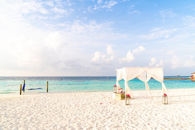 wedding arch on beach with tropical Maldives resort and sea