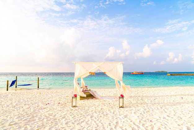 wedding arch on beach with tropical Maldives resort and sea