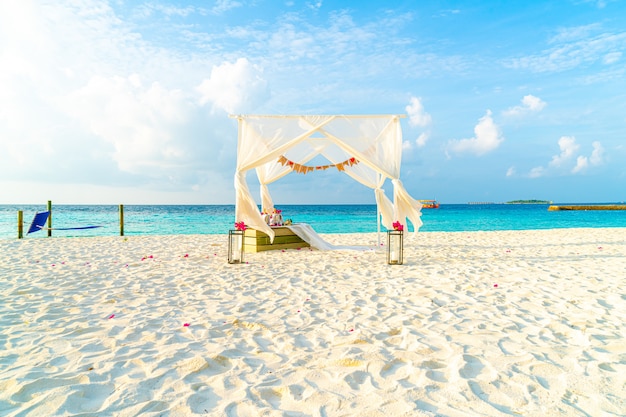 wedding arch on beach with tropical Maldives resort and sea