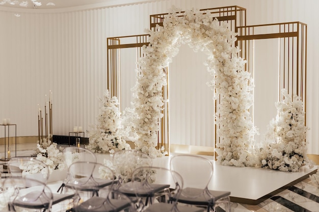 Photo wedding arch decorated by white flowers