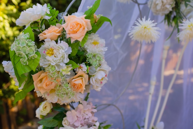 Wedding arch decorated with cloth and flowers outdoors. Beautiful wedding set up.