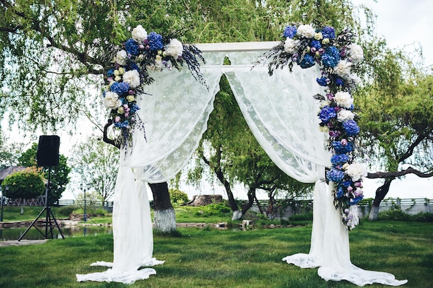 Wedding arch decorated with fabric and flowers.