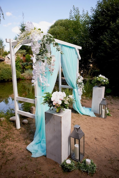 Wedding Arch of turquoise color on background lake