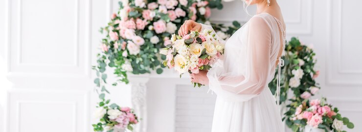 Photo 텍스트를위한 공간으로 웨딩 배너입니다. 꽃 배경에 그녀의 손에 꽃다발 신부