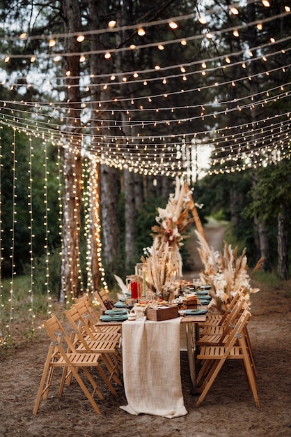 Wedding banquet area in a pine forest with an arch on the background for several people