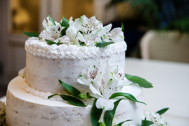 Wedding or birthady party white flower cake Cutting of the wedding cake bride and groom