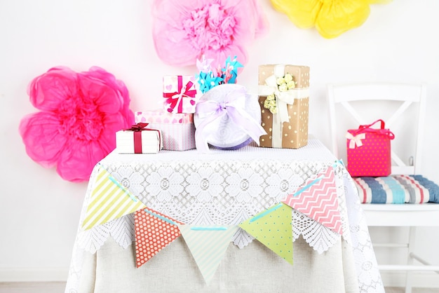 Wedding or birthday gifts on decorated table, on bright background