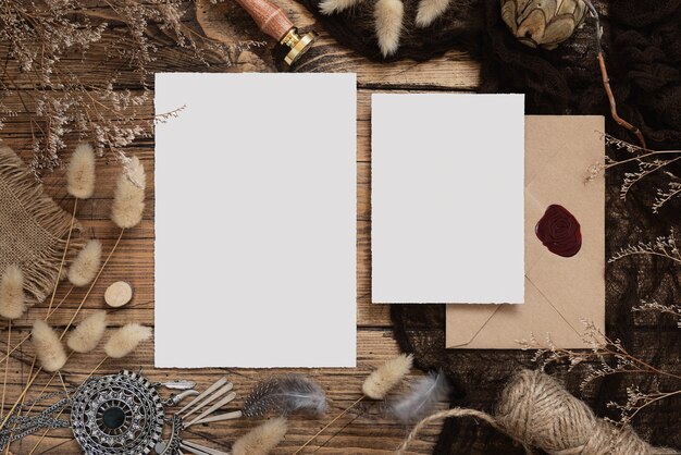 Wedding blank cards laying on a wooden table with bohemian decoration around