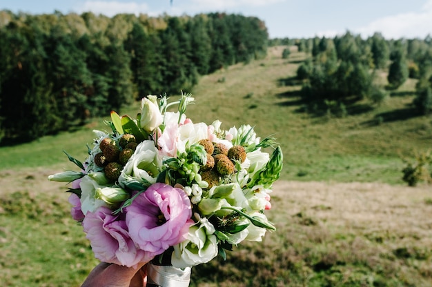 Wedding bouquet in bride's hands. Field view, place for text.