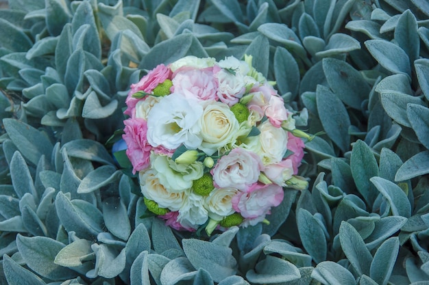 Bouquet da sposa di fiori e vegetazione sulle foglie verdi