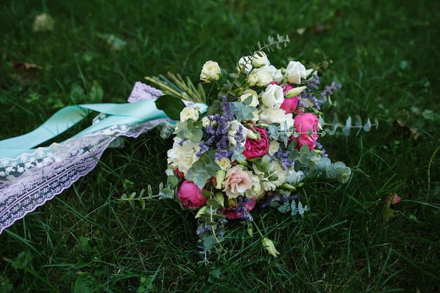 Wedding bouquet of fresh flowers on green grass.