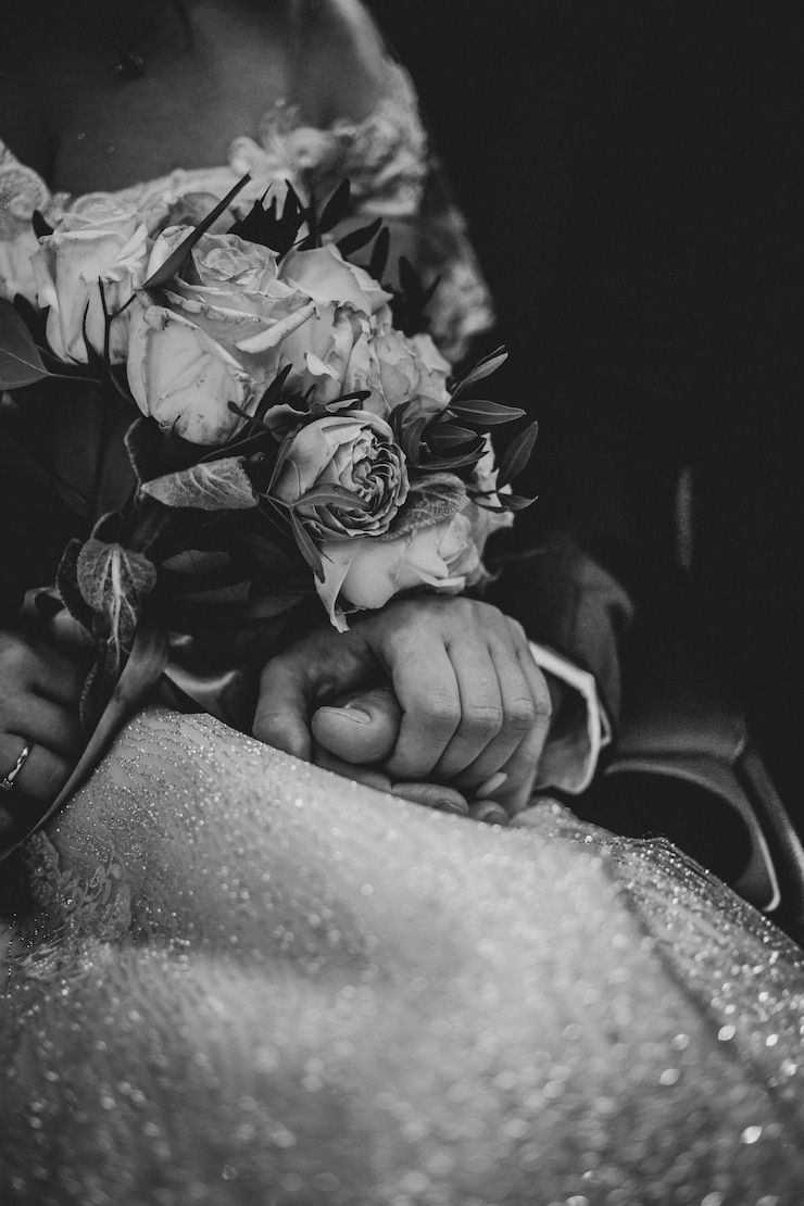 Photo wedding bouquet in hands of bride and groom