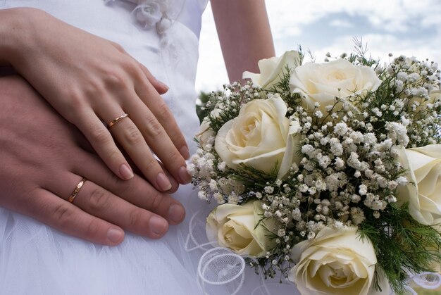 Wedding bouquet and hands with rings