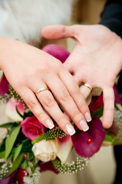 Wedding bouquet and hands with rings