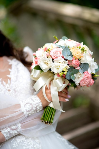 Wedding bouquet large in the hands of the bride decor of white and pink roses