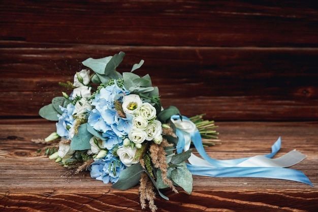 Wedding bouquet lying on a wooden surface.