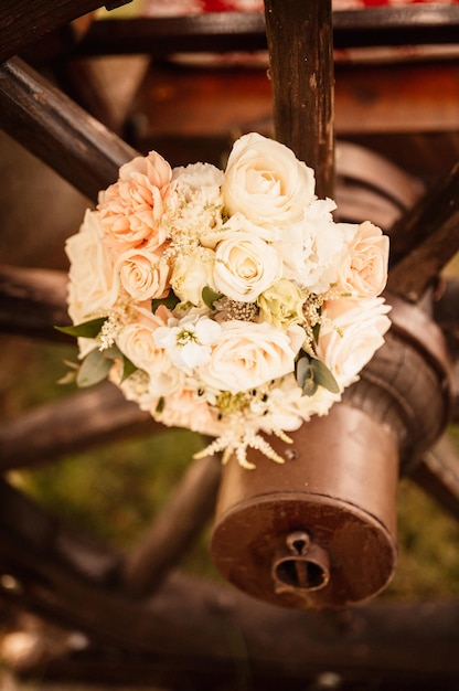 Wedding bouquet outside the bride in a beige dress holds the flowers wedding bouquet of flowers and greenery