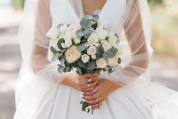 Wedding bouquet in pastel colors in the hands of the bride of roses eustoma peonies carnations and eucalyptus