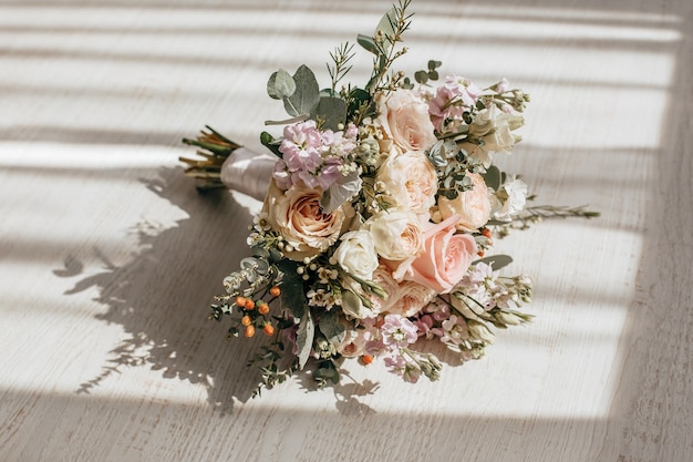 Foto bouquet da sposa di fiori di peonie sul pavimento degli sposi