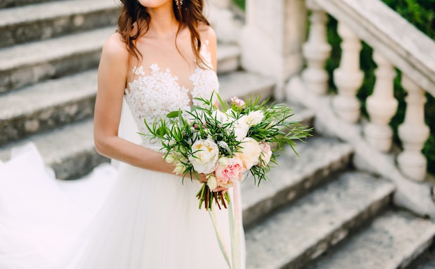 Wedding bouquet of peonies in the hands of the bride wedding in