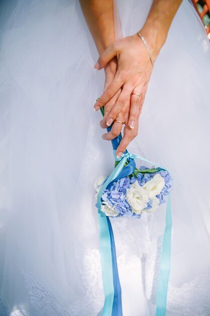 Wedding bouquet of roses and hydrangea flowers in hands of bride