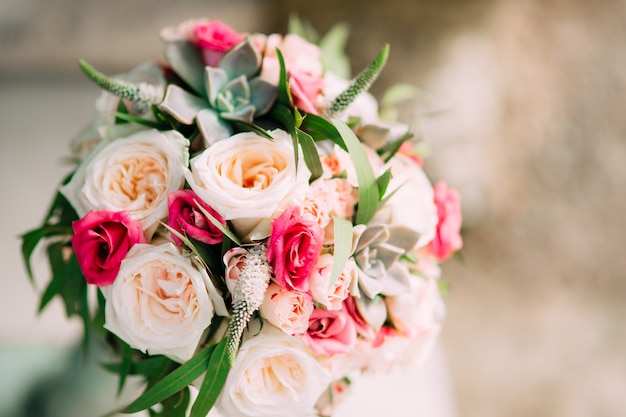 Wedding bouquet of roses peonies and succulents on the rocks w