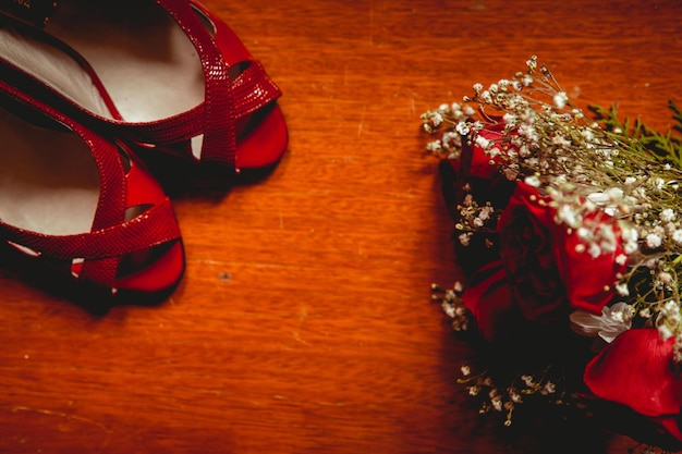 Wedding bouquet and shoes on wooden table