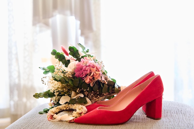 赤いハイヒールシューズでテーブルの上の結婚式の花束