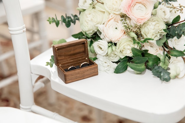 Wedding bouquet of white flowers and wedding rings. Details of the wedding ceremony.