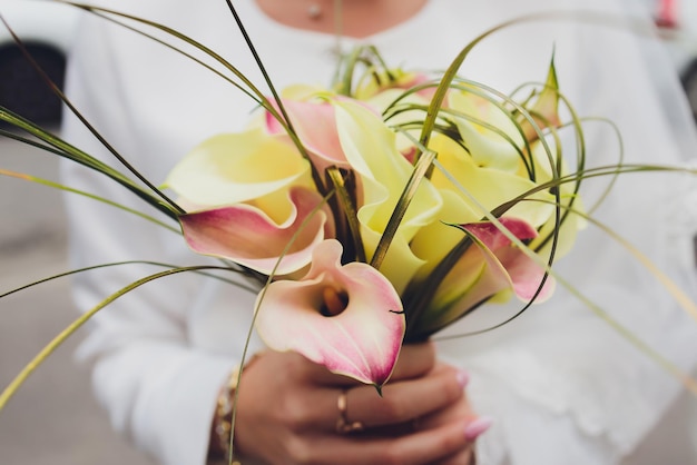 Wedding bouquet of white lilies fashionable closeup in hands