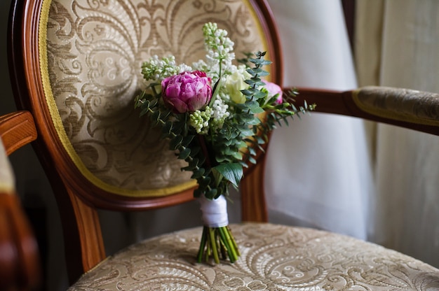 Wedding bouquet of white roses and purple peonies.