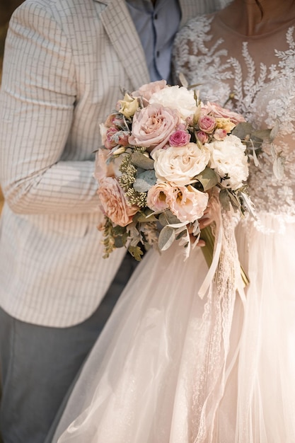 Bouquet da sposa con fiori naturali freschi nelle mani della sposa