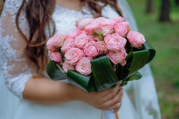 Wedding bouquet with pink roses in bride hand