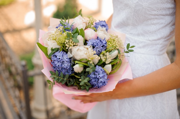 Wedding bouquet with pions in hands of the bride