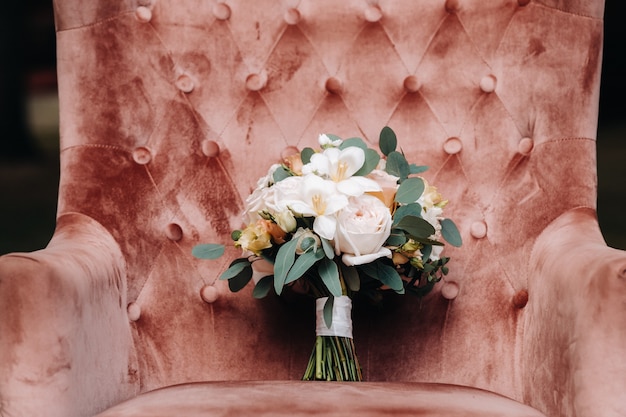 Bouquet da sposa con rose sul tavolo e un fiore all'occhiello