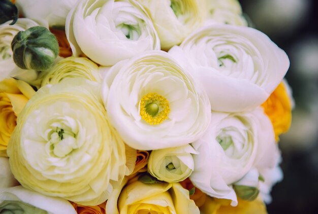 Wedding bouquet with white carnations and ranunculi. delicate bouquet in yellow and white. eucalyptus leaves.