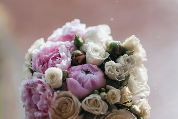 Wedding bouquet with white and pink peonies with raindrops