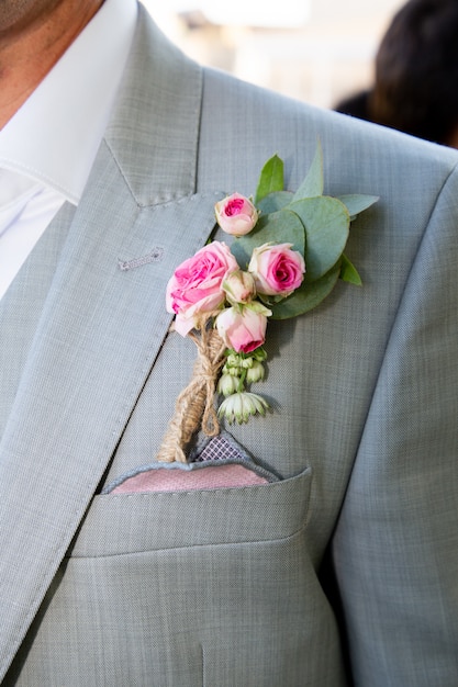 Photo wedding boutonniere on grey suit of the groom