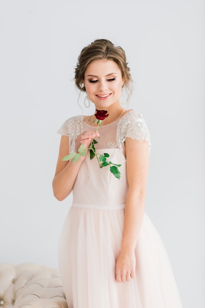 Wedding. Bride in beautiful dress indoors in white studio interior like at home.