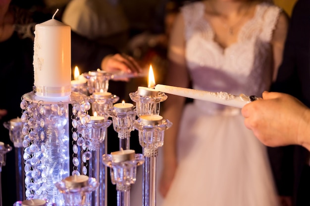 결혼식 신부와 신랑 부부는 사랑 결혼식 개념의 상징으로 결혼식 촛불 불꽃에 촛불을 켰다