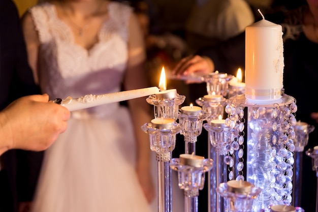 Foto le coppie dello sposo e della sposa di nozze hanno acceso le candele alla cerimonia di matrimonio.