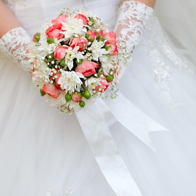 Wedding bunch of flowers in hands of the bride