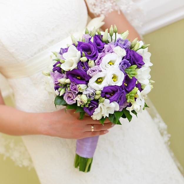 Wedding bunch of flowers in hands of the bride