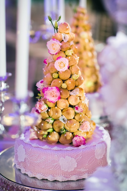 Torta nuziale decorata con fiori color crema su supporto