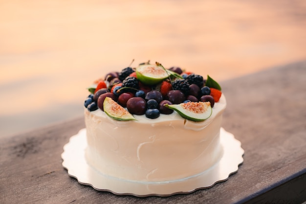 Wedding cake of figs cherries and berries with a white cream o