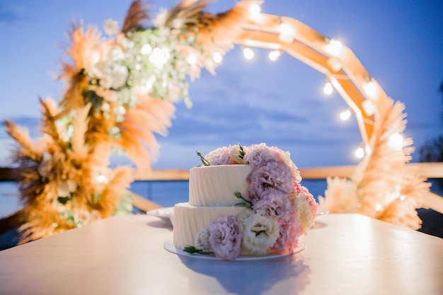 Wedding cake near the arch in the evening