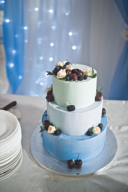 Wedding cake in three tiers decorated with fresh flowers and berries 257