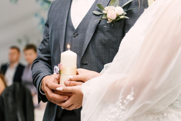 The wedding candle in the hands of the bride and groom the candle is the family hearth at the wedding Candle in hand at the wedding