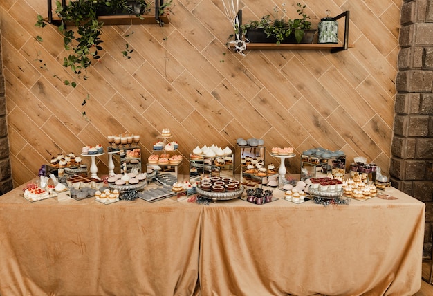 Свадебный кенди-бар наполнен различными десертами. свадебный стол на банкете