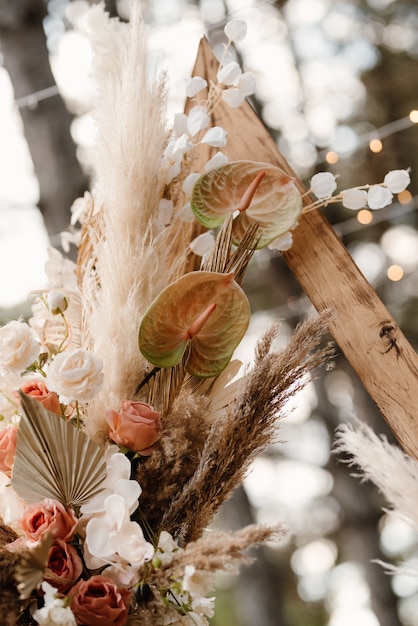 Photo wedding ceremony area with dried flowers in a meadow in a pine brown forest